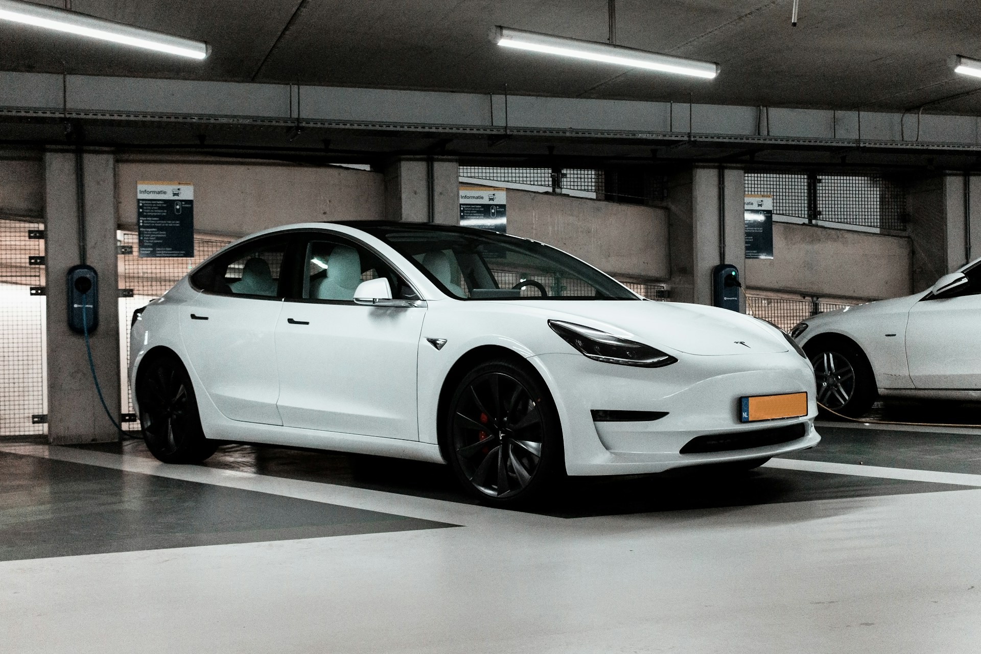 A white Tesla charging.